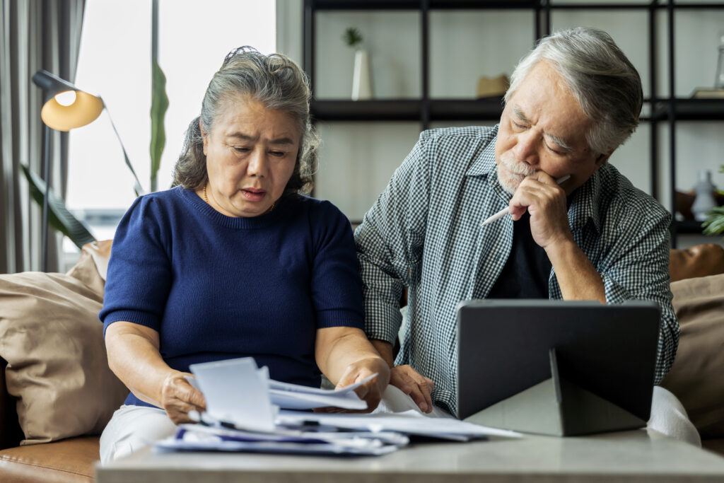 Elderly person sitting alone, worried about Financial insecurity & emotional stress