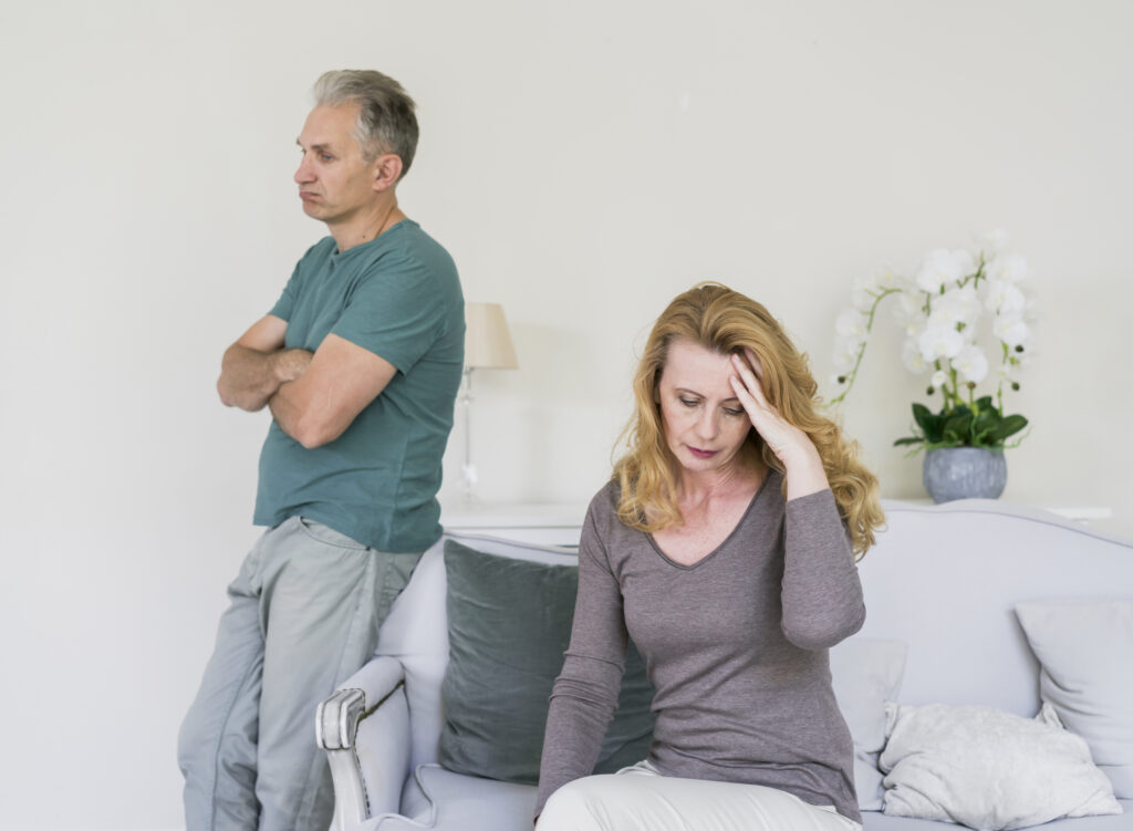 Elderly couple sitting apart while receiving emotional support and marriage counselling in old age.