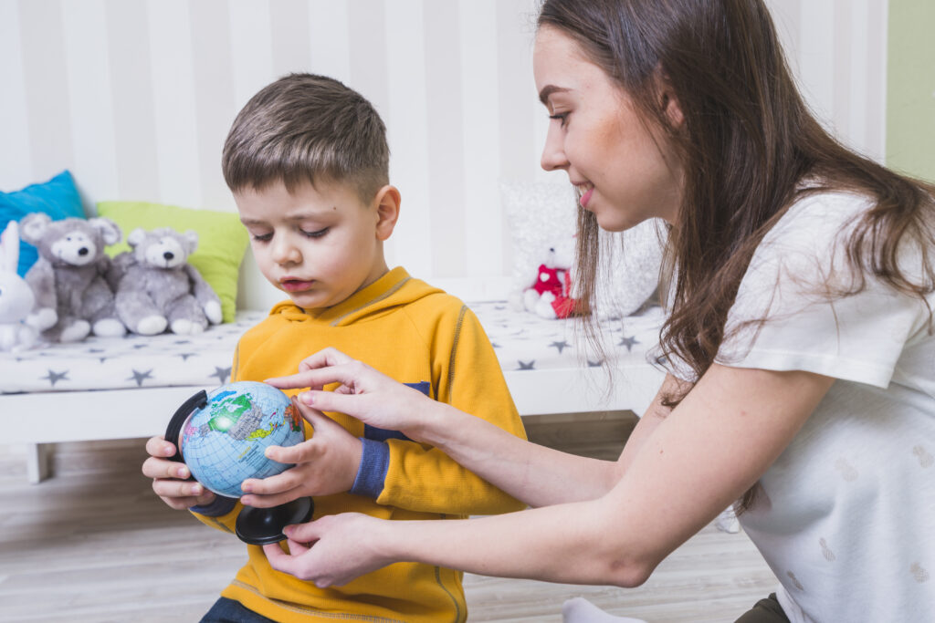 Autistic children following a daily routine chart with support from a caregiver in a calm home environment.