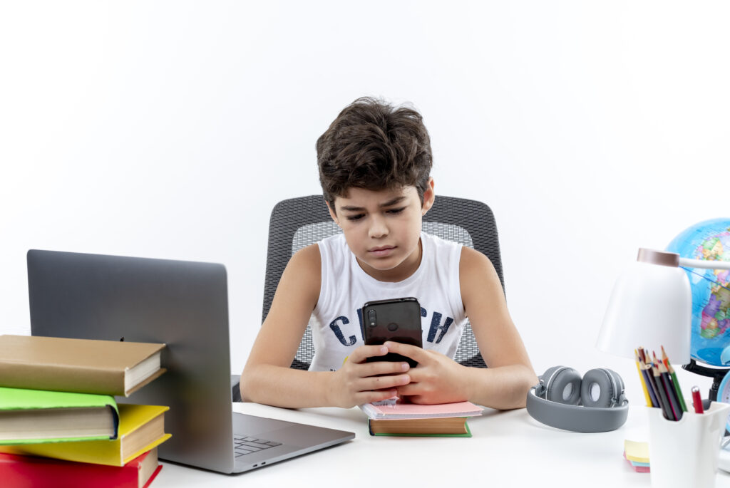 Student experiencing cyberbullying on a laptop while receiving support from a teacher, highlighting prevention and intervention in schools.