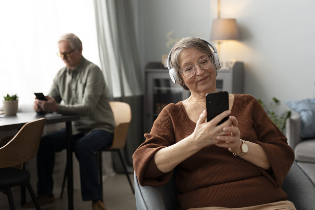Senior using social media on a tablet while smiling, promoting connection, digital safety, and mental well-being.